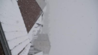 Çatıları olan şehrin üzerinde şiddetli kar yağışı