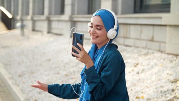 Bliskowschodnia Kobieta Hidżabie Słucha Muzyki Słuchawkami Tańczy Świeżym Powietrzu Niezależność — Wideo stockowe