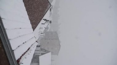 Çatıları olan şehrin üzerinde şiddetli kar yağışı