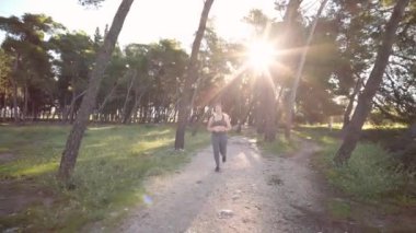 Vücut pozitifliği ve beden ölçülerinde bir bayan sporcu parkta koşuyor. Kilo kaybı ve aktif yaşam tarzı kavramı