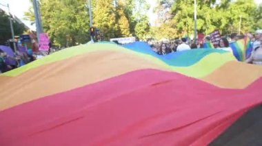 Sırbistan, Belgrad - 9 Eylül 2023: Belgrad Gururu. Belgrad sokaklarında geçit törenine katılanlar. Geleneksel Onur Yürüyüşü 'nde destekçiler gökkuşağı bayrakları ve işaretler sallıyor