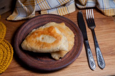 Ahşap masada iki ayrı kızarmış etli kil tabak. Fast food yemeği ve sofra takımının eski ahşap arka planda kırsal tarzda kompozisyonu.