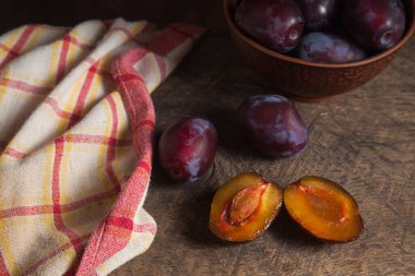 Sulu yaz eriği meyvesi. Kaliteli ahşap arka planda bir sürü olgun tatlı erik. Arka planda erikler olan kil plaka