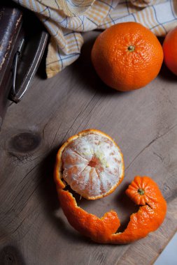 Taze portakal, portakal, mandalina, mandalina, mandalina, narenciye ve bir meyvenin yarısı ahşap yaban domuzu üzerine soyulmuş.