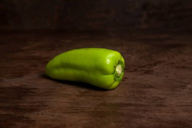 Yeşil dolmalık biber (capsicum) tatlı dolmalık biber olarak bilinir, eski ahşap arka planda kırmızı biber. Sebze koleksiyonu.