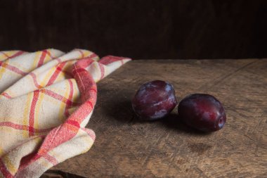 Sulu yaz eriği meyvesi. İki olgun tatlı erik eski ahşap arka planda.