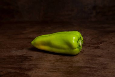 Yeşil dolmalık biber (capsicum) tatlı dolmalık biber olarak bilinir, eski ahşap arka planda kırmızı biber. Sebze koleksiyonu.