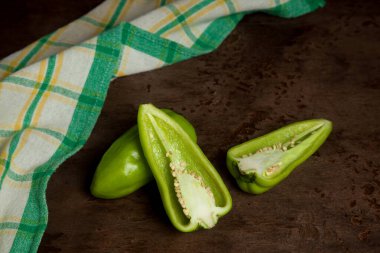 Tam ve yeşil dolmalık biber (capsicum) tatlı dolmalık biber olarak bilinir, yeşil mutfak havlusu ve eski ahşap arka plan. Sebze koleksiyonu.