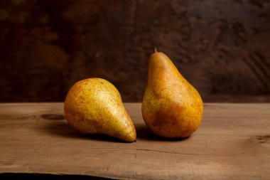 Two ripe juicy pear fruits on vintage wooden background