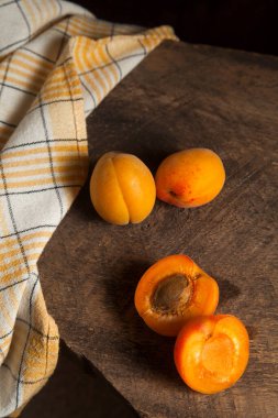 İki tam ve yarım kayısı meyvesi eski ahşap arka planda