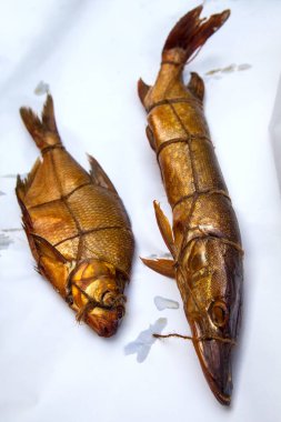 Tütsülenmiş tatlı su turnabalığı ve tütsülenmiş balık. Beyaz kağıt üzerinde kullanmak için baharatlı, nefis kurutulmuş füme balık.