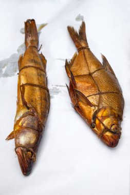 Tütsülenmiş tatlı su zander ve tütsüleme evindeki sıradan balık iştahlı. Beyaz kağıt üzerinde kullanmak için baharatlı, nefis kurutulmuş füme balık.