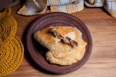 Ahşap masada iki ayrı kızarmış etli kil tabak. Fast food akşam yemeği kompozisyonu - iki turta ile vintage ahşap arka planda domuz pastası.