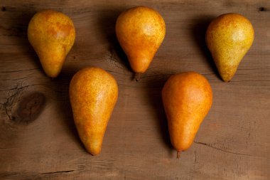 Eski ahşap arka planda birkaç olgun armut meyvesi.