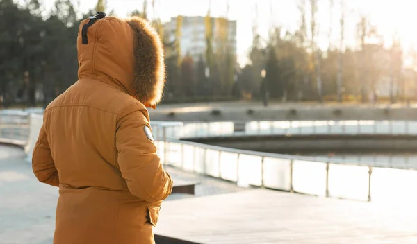 冬が来る 冷たい公園の背景に冬のジャケットを着た男 季節と人 — ストック写真