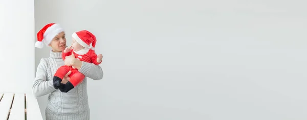 Stock image Fatherhood and holidays concept - Father with his baby boy wearing Santa hats celebrating Christmas.