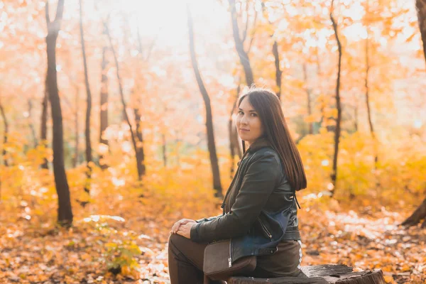 秋天的一天 一个小女孩一个人坐在木柴树桩上 在森林里散步 孤独和忧郁的概念 — 图库照片