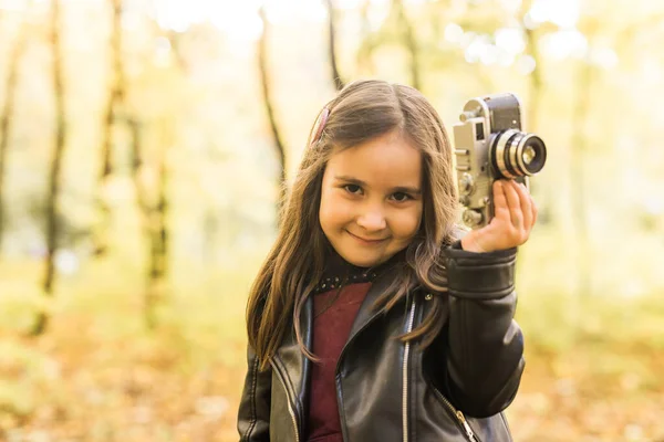 一个小女孩用老旧的复古相机拍了一张秋天里的照片 休闲和业余爱好概念 — 图库照片