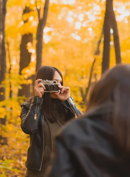 秋の公園のレトロカメラでカリスマ娘を撮影している母 趣味とレジャーのコンセプト — ストック写真