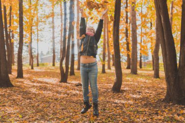 Sonbahar parkında düşen yaprakları fırlatan mutlu çocuk.. Sonbahar parkında yürüyen çocuklar.