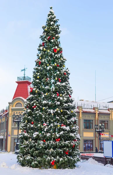 decorated christmas tree in town square - xmas and winter holidays in cityscape