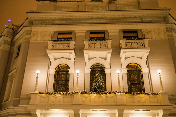 市内中心部の建物のバルコニーには 照明やボールの泡と新年のガーランドで飾られたクリスマスツリー クリスマスの飾り — ストック写真