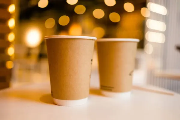 Закрыть Две Картонные Кофейные Чашки Унести Стол Боке Фоне Кафе — стоковое фото