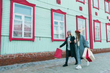 Mutlu arkadaşlar alışveriş yapıyor. Alışveriş torbalarıyla alışveriş yapan iki güzel genç kadın. Tüketim ve arkadaşlık kavramı.