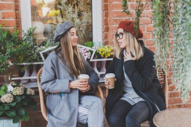 Genç bayan en iyi arkadaşlar birbirleriyle konuşuyor. Boş zamanlarında ilginç konuları tartışıyorlar. Hipster kızlar, eğleniyorlar ve eğleniyorlar.