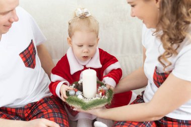 Baby child with hearing aid and cochlear implant having fun with parents in christmas room. Deaf and health