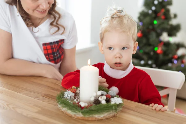 Baby child with hearing aid and cochlear implant having fun with parents in christmas room. Deaf and health