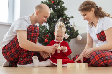 Toddler child with cochlear implant decorating christmas tree deafness and innovating medical technologies for hearing aid