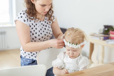 Anne, sağır küçük kızı için koklear implant takmasına yardım ediyor. İşitme cihazı ve sağırlık