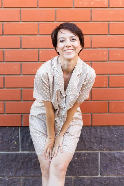Cheerful Woman Home Wear Pajama Outdoor Brick Wall Background Emotions — Stock Photo, Image