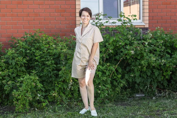 Vrolijke Vrouw Huis Dragen Pyjama Outdoor Baksteen Muur Achtergrond Emoties — Stockfoto