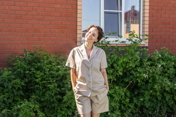 Vrolijke Vrouw Huis Dragen Pyjama Outdoor Baksteen Muur Achtergrond Emoties — Stockfoto
