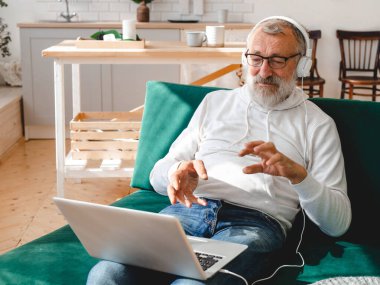 Yaşlı bir adam laptopta çocuklarla görüntülü konuşma yapıyor. Modern teknoloji iletişim interneti.