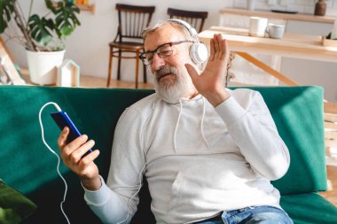 Yaşlı bir adam laptopta çocuklarla görüntülü konuşma yapıyor. Modern teknoloji iletişim interneti.