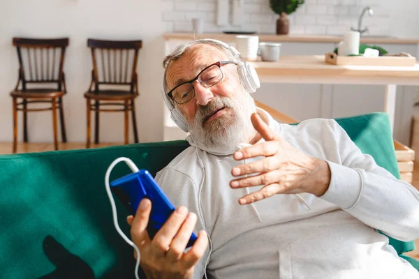 Yaşlı bir adam laptopta çocuklarla görüntülü konuşma yapıyor. Modern teknoloji iletişim interneti.