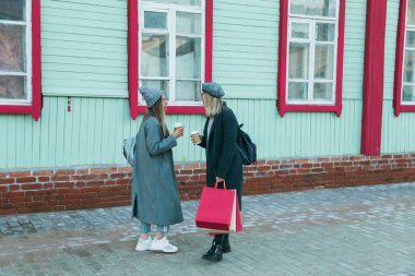 Mutlu arkadaşlar alışveriş yapıyor. Alışveriş torbalarıyla alışveriş yapan iki güzel genç kadın. Tüketim ve arkadaşlık kavramı.