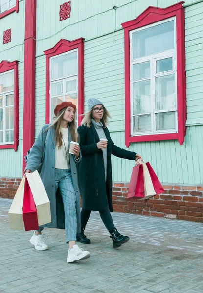 Happy friends shopping. Two beautiful young women enjoying shopping in city with shopping bags - consumerism and friendship concept