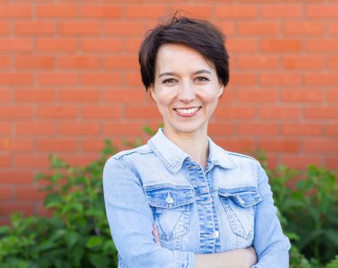 Verandada şık elbiseler giyen neşeli genç bir kadın. Mutlu gülümseyen kız dışarıda eğleniyor. Mutlu kadın yazın tadını çıkarıyor