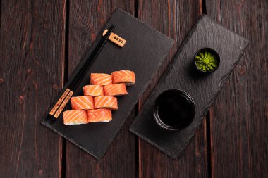 Sushi roll philadelphia with salmon and cucumber and cream cheese on black background. Sushi menu. Japanese food