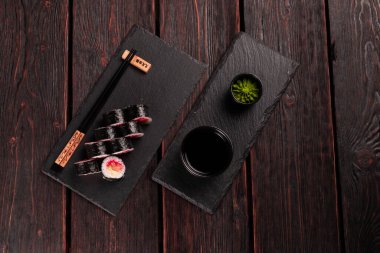 Maki sushi roll with salmon avocado and tobiko caviar served black board close-up - Japanese food