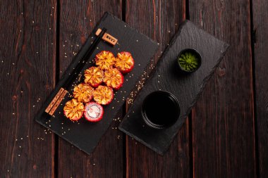 California sushi roll with crab, avocado, cucumber and tobiko caviar served on black board - Japanese food.