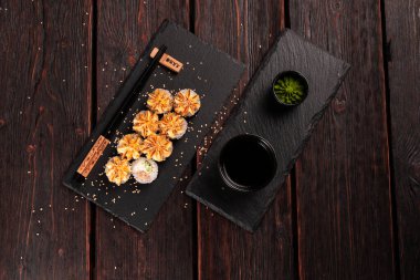 Maki sushi roll with salmon avocado and tobiko caviar served on black board p - Japanese food