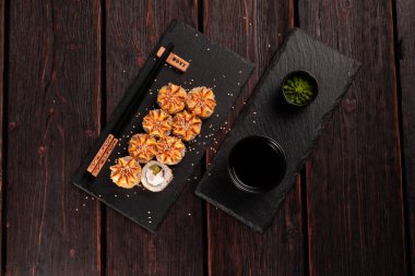 Sushi roll philadelphia with salmon and cucumber and cream cheese on black background. Sushi menu. Japanese food