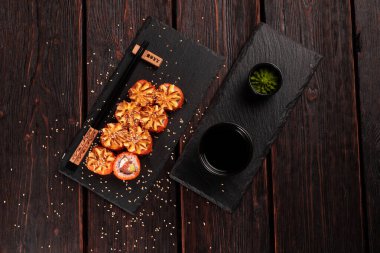 California sushi roll with crab, avocado, cucumber and tobiko caviar served on black board - Japanese food.