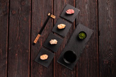 Set of Gunkan Maki Sushi with different types of fish salmon, scallop, perch, eel, shrimp and caviar on wooden table background. Sushi menu. Japanese food sushi set gunkan