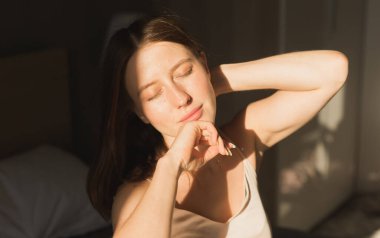 Güzel kadın onun yatağında uyanmak o gülümseyen ve germe